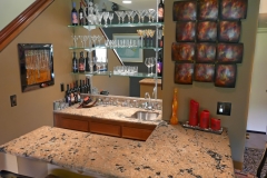 Wet Bar with Granite counter tops, mirrored walls and glass shelving